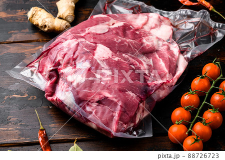 Lamb meat raw pack, with ingredients and herbs, on old dark wooden table background 88726723