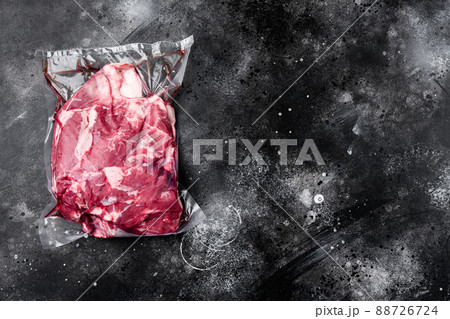 Lamb meat pack ready for cooking, on black dark stone table background, top view flat lay, with copy space for text 88726724