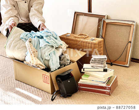 断捨離中の高齢女性と額縁とバスケットと衣類 88727058