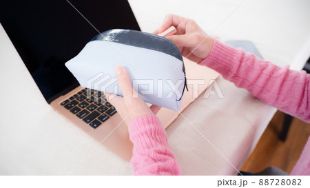 化粧ポーチと働く女性のPCと手元 88728082
