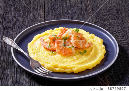 polenta with fried shrimps on plate, top view 88729897
