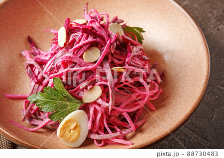 Daikon and beet salad dressed with mayonnaise or yogurt, garnished with almonds and quail eggs 88730483