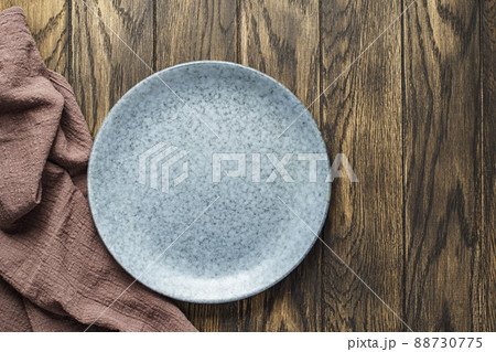 Empty bluish plate on oak wooden background Empty bluish plate on oak wooden background 88730775