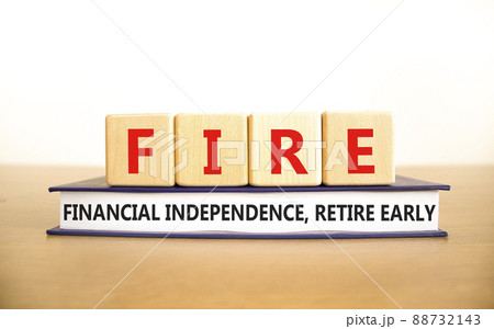 FIRE financial independence retire early symbol. Concept words FIRE financial independence retire early on cubes on book. White background. Business FIRE financial independence retire early concept. 88732143