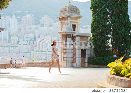 a bright beautiful girl in a light dress and hat walks along the streets of Monaco in sunny weather in the summer, luxury apartments of Monte Carlo on background a bright beautiful girl in a light dress and hat walks along the streets of Monaco in sunny weather in the summer, luxury apartments of Monte Carlo on background 88732584