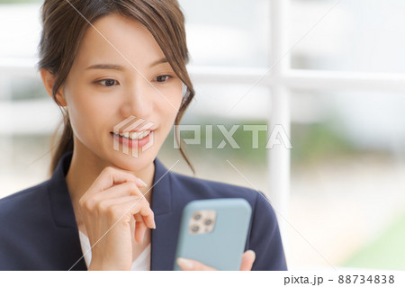 スマートフォンを持った女性　スーツ 88734838