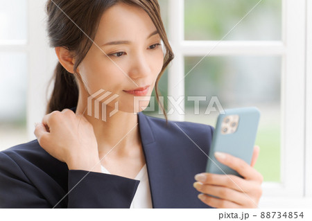 スマートフォンを持った女性 スーツ スマートフォンを持った女性 スーツ 88734854