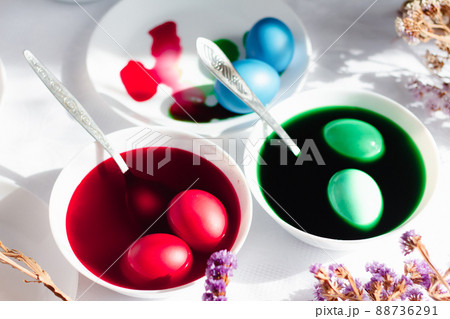 top view of easter table with plates and paints for eggs. Coloring eggs for spring holiday easter, colorful eggs top view of easter table with plates and paints for eggs. Coloring eggs for spring holiday easter, colorful eggs 88736291