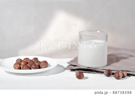 Vegan plant based milk in glass. Alternative hazelnut milk and nuts. Healthy vegetarian and vegan drink concept Vegan plant based milk in glass. Alternative hazelnut milk and nuts. Healthy vegetarian and vegan drink concept 88738398