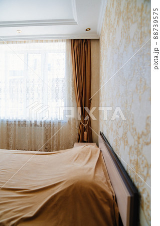 bed with beige blanket in the bedroom with a classic interior. bed with beige blanket in the bedroom with a classic interior. 88739575