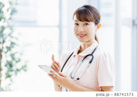 施設内でスマホを操作する医療従事者の女性 88741573