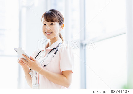 施設内でスマホを操作する医療従事者の女性 88741583