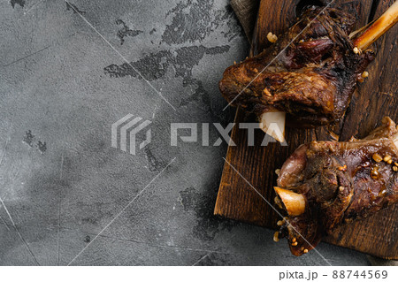 Braised Lamb Shanks with Sauce and Herbs, on gray stone table background, top view flat lay, with copy space for text Braised Lamb Shanks with Sauce and Herbs, on gray stone table background, top view flat lay, with copy space for text 88744569