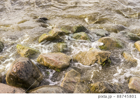 Sea stones and waves on the beach. Summer background. 88745801