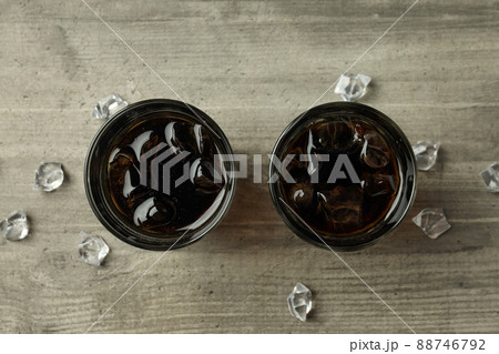 Glass of cola and ice on gray textured table 88746792