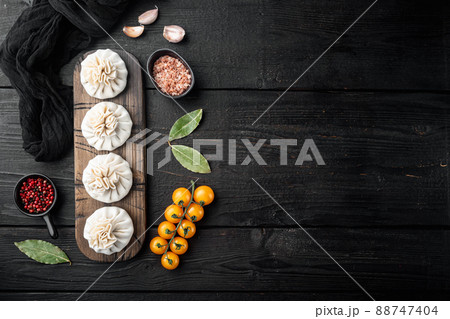 Homemade, traditional chinese pan fried dumplings, on black wooden table background, top view flat lay, with copy space for text 88747404