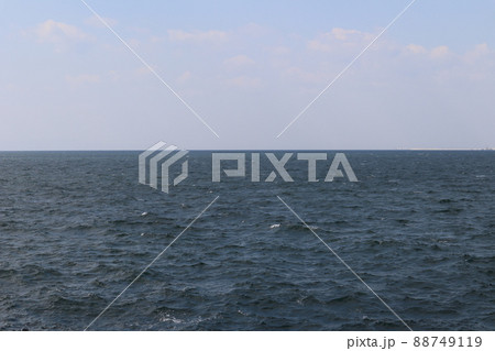 波のある濃い青色の海面の海と水平線と雲と薄い青空のある風景 88749119