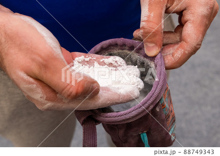 Climber applying chalk powder for rock climbing in bouldering gym. Climber applying chalk powder for rock climbing in bouldering gym. 88749343