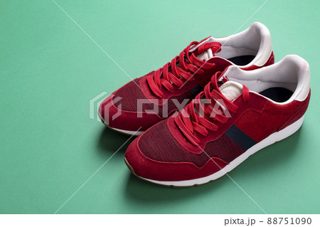 New unbranded running sneaker or trainer on green background. Men's sport footwear.  88751090