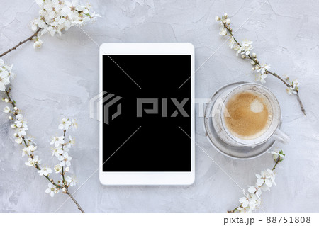 Digital tablet on spring floral background, white cherry blossom flowers and morning espresso coffee 88751808