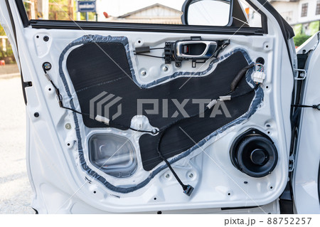 Unpack white steel vehicle door panel with replaced with new speaker in auto accessories shop 88752257