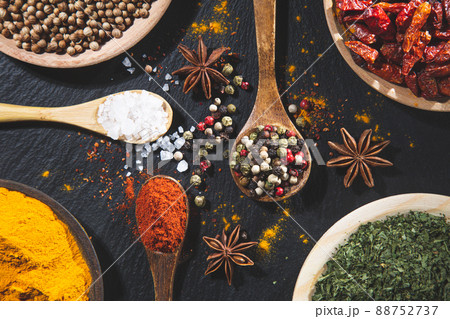 Background with variety of spices and herbs on black background top view. Cooking ingredients and condiments concept. Background with variety of spices and herbs on black background top view. Cooking ingredients and condiments concept. 88752737