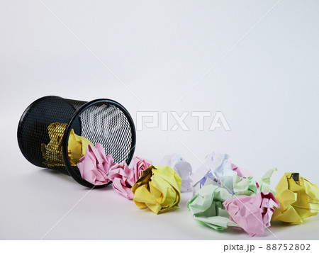 A small black basket made of round iron fell down. It is used to put the trash, documents that are not working and are overflowing to the outside. In the white background there is a copy space. A small black basket made of round iron fell down. It is used to put the trash, documents that are not working and are overflowing to the outside. In the white background there is a copy space. 88752802