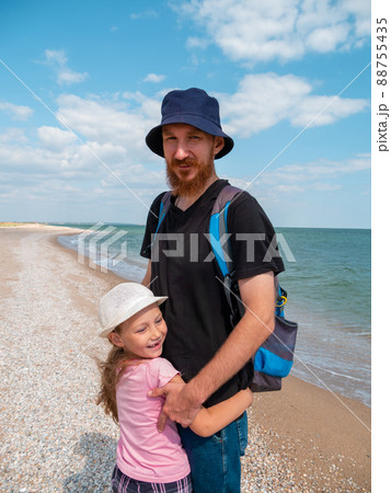 Happy family father daughter hugging on marine landscape. Bearded dad with child in hands having fun together Happy family father daughter hugging on marine landscape. Bearded dad with child in hands having fun together 88755435