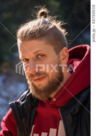 Outdoor vertical portrait of blond bearded smiling hipster man in nature 88760638