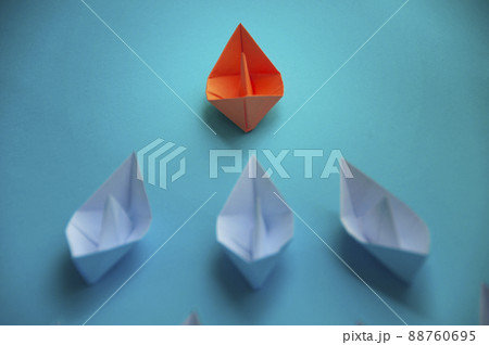 Leadership Concept - Orange color paper ship origami leading the rest of the white paper ship on blue cover background. Copy space concept Leadership Concept - Orange color paper ship origami leading the rest of the white paper ship on blue cover background. Copy space concept 88760695
