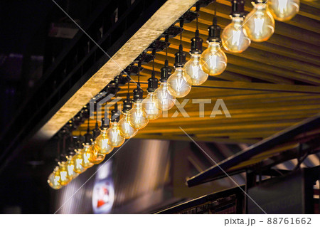 Tungsten circle lamp light on the row, stick on the wood kiosk ceiling. 88761662