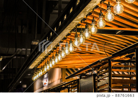 Tungsten circle lamp light on the row, stick on the wood kiosk ceiling. 88761663