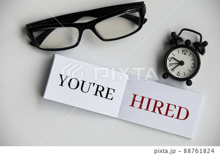 You're hired text on notepad with alarm clock and glasses. You're hired text on notepad with alarm clock and glasses. 88761824