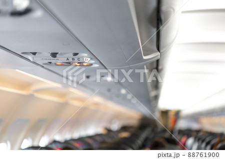 closeup airplane Console panel; lamp, light, need help button, air condition, sefty belt and no smoking lighting sign. 88761900