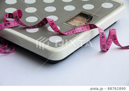 Measuring tape and weight scale on white background. Weight loss concept Measuring tape and weight scale on white background. Weight loss concept 88762890