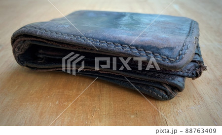 Old wallet on the wooden table. Old wallet on the wooden table. 88763409
