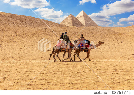 Egyptian men on camels in the sands of Giza near the Pyramids 88763779