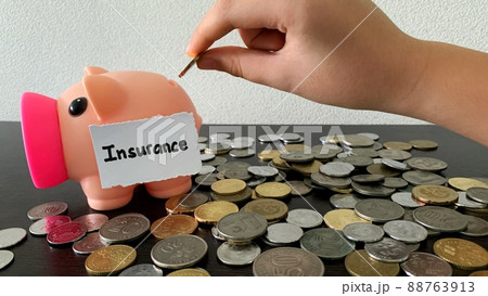 Hand putting coin money into piggy bank for insurance payment. Money concept. Hand putting coin money into piggy bank for insurance payment. Money concept. 88763913
