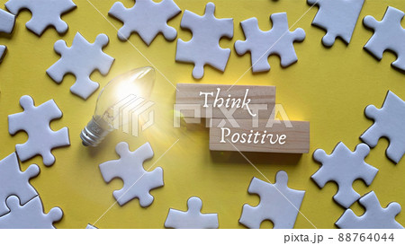 Top view of words - Think positive. With jigsaw puzzle and bulb background. 88764044