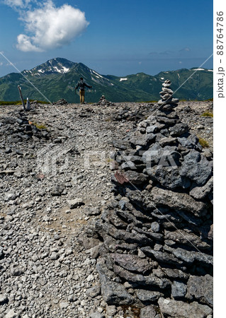 北アルプス・祖父岳のケルンと登山者・黒部五郎岳の眺め 88764786