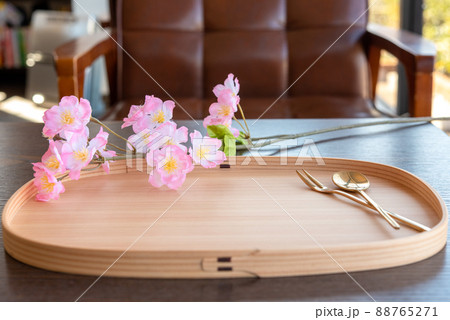 まげわっぱ盆に乗ったゴールドのカトラリー スプーンとフォーク 桜の花 カフェの椅子 まげわっぱ盆に乗ったゴールドのカトラリー スプーンとフォーク 桜の花 カフェの椅子 88765271