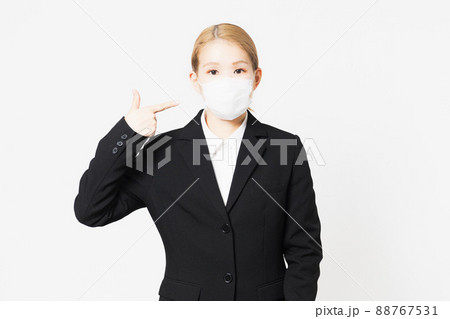 ジャケットを着たマスクを指差す若い女性 88767531
