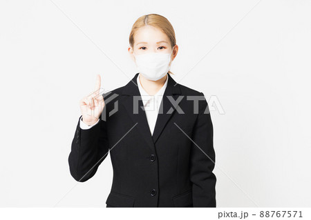 マスクを着けたポイントを示す若い女性 88767571