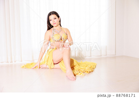 黄色のベリーダンス衣装で座るセクシーな女性 88768171