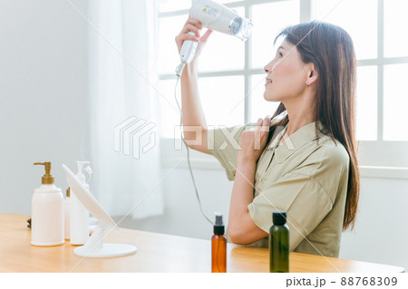 ドライヤーを使うミドル世代の女性（笑顔） 88768309