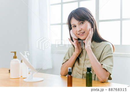 鏡を見るミドル世代の女性（ファンデーション・カメラ目線） 88768315