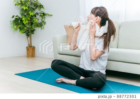 部屋でヨガをするミドル世代の女性(プロテインを飲む) 部屋でヨガをするミドル世代の女性(プロテインを飲む) 88772301