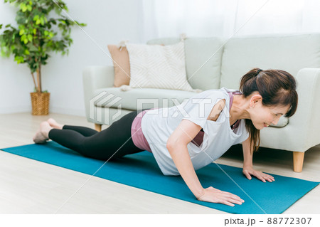部屋で腕立て伏せをするミドル世代の女性 88772307
