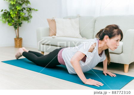 部屋で腕立て伏せをするミドル世代の女性 部屋で腕立て伏せをするミドル世代の女性 88772310