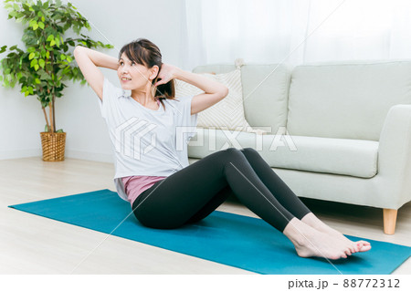 部屋で腹筋をするミドル世代の女性(ねじる) 部屋で腹筋をするミドル世代の女性(ねじる) 88772312